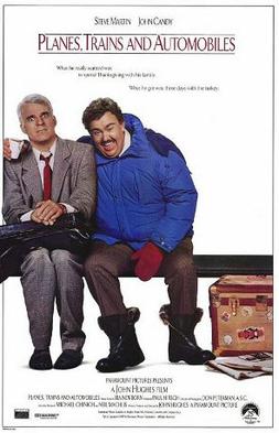 Steve Martin and John Candy sit on a bench. for the movie poster of Planes, Trains, and Automobiles.